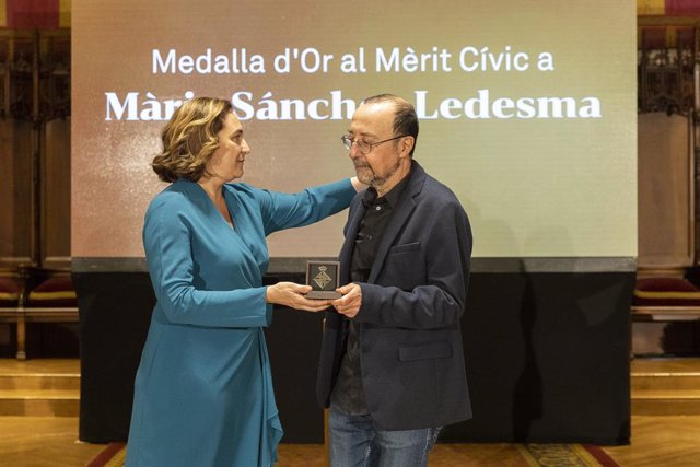 L'alcaldessa de Barcelona, Ada Colau, lliura la Medalla d'Or al Mèrit Cívic a títol pòstum a la periodista de RTVE Mària Sánchez Ledesma al seu marit, el també periodista Manel Lucas en un acte en el Va salar de Cent de l'Ajuntament.