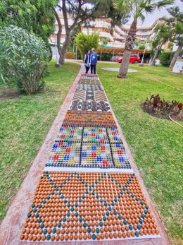 Imagen de la alfombra elaborada con cápsulas de café usadas, que este jueves será pisada en una performance educativa y artística que pretende llamar la atención sobre la huella, el patrimonio y el cuidado del planeta.