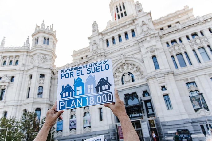 Una persona sujeta una pancarta durante una protesta sobre el Plan 18000 Venta de Suelo, frente a las puertas del Ayuntamiento 
