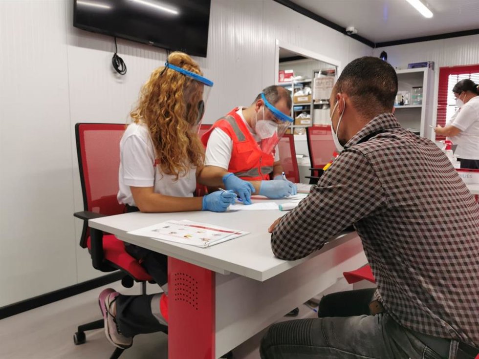 Archivo - Voluntarios de Cruz Roja atienden a una persona llegada en patera. 