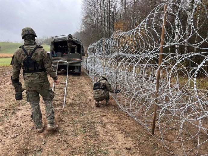 Archivo - Labores de reparación de la valla levantada en el lado de la frontera polaca con Bielorrusia.