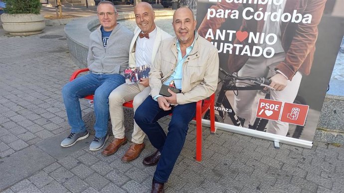 Hurtado (centro), en su banco móvil, junto a dos vecinos de Córdoba.