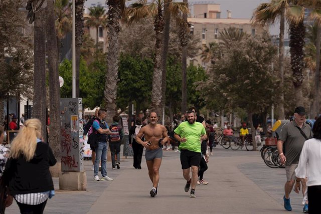 Varias personas aprovechan el buen tiempo para dar un paseo por el paseo marítimo de la playa de la Barceloneta, a 25 de abril de 2023, en Barcelona, Catalunya (España).