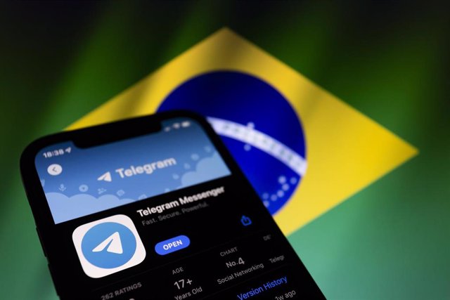 Archivo - Aplicación de Telegram junto a la bandera de Brasil