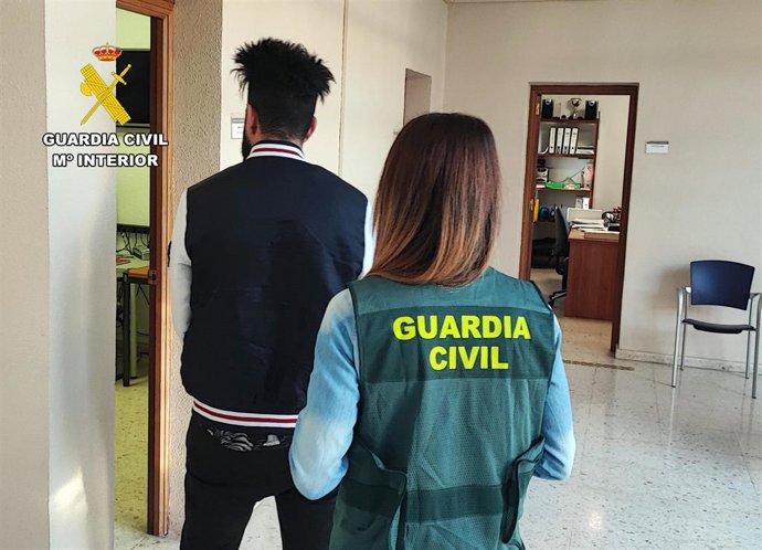 Una agente de la Guardia Civil custodia al detenido