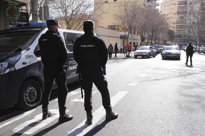 Archivo - Dos policias nacionales en Palma junto al furgón. 