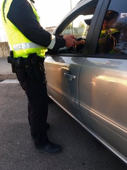 Un policía local realiza una prueba de alcoholemia a un conductor.
