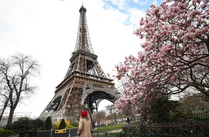 Archivo - PARIS, March 20, 2023  -- A woman passes by magnolia blossoms at the Champ de Mars near the Eiffel Tower in Paris, France, March 19, 2023.,Image: 763930024, License: Rights-managed, Restrictions: , Model Release: no, Credit line: Gao Jing / Xi