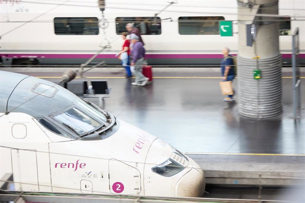 Viajeros con maletas en uno de los andenes de la estación Almudena Grandes-Atocha Cercanías