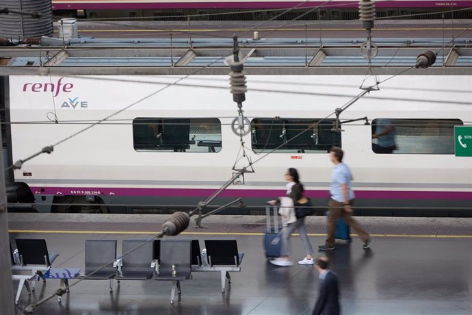 Viajeros con maletas en uno de los andenes de la estación Almudena Grandes-Atocha Cercanías