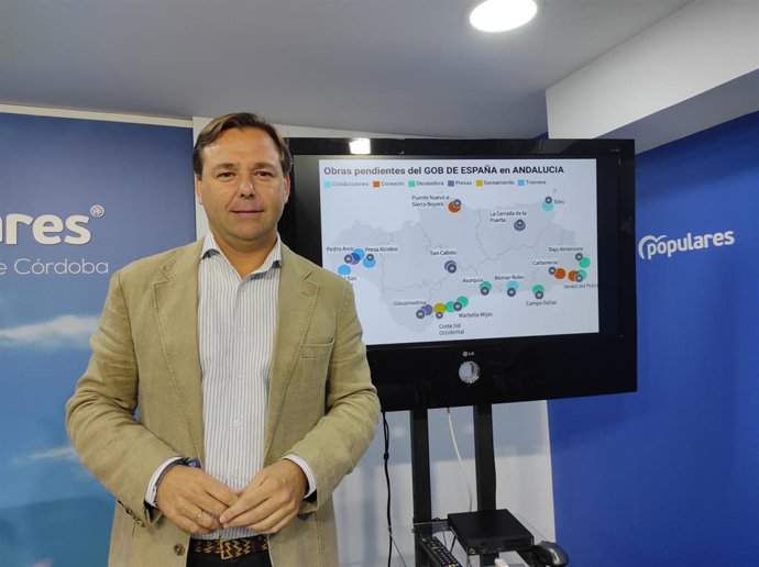 El secretario general del PP de Andalucía, Antonio Repullo, con el mapa de obras hídricas pendientes en la región por el Gobierno.