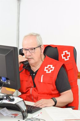Archivo - Un voluntario de Cruz Roja realiza una llamada.