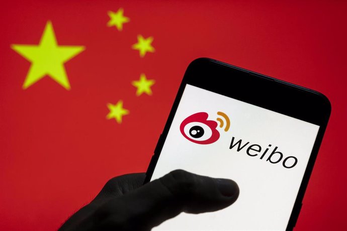 Archivo - Bandera china y logotipo de Weibo en un teléfono móvil