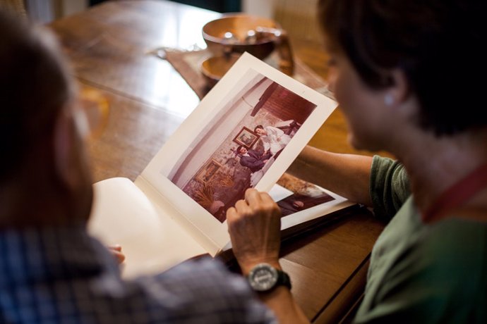 Archivo - Primer punto de vista de un hombre mayor mirando un viejo álbum de fotos de boda