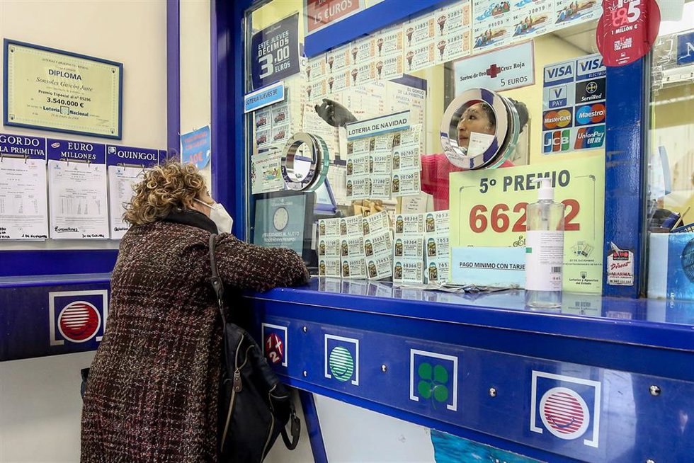 Archivo - Una persona compra en la administración de lotería 