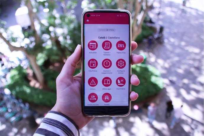 Una persona sostiene un móvil con la nueva aplicación del Ayuntamiento de Palma abierta.