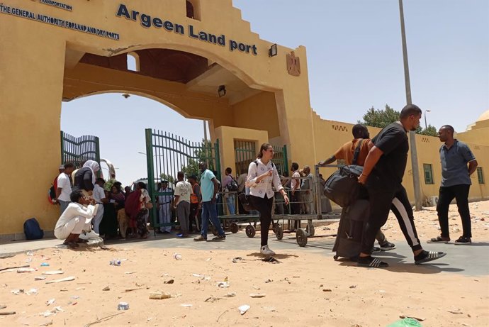 Un grupo de personas cruza la frontera con Egipto desde Sudán en 27 de abril a través del puesto de Argin, en medio de los combates entre el Ejército sudanés y las paramilitares Fuerzas de Apoyo Rápido (RSF)