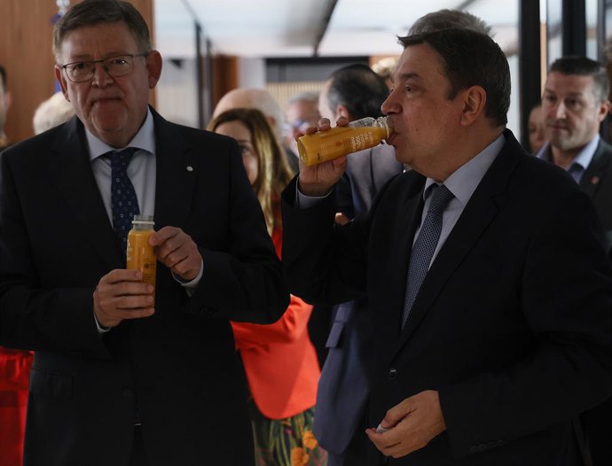 El presidente de la Generalitat Valenciana, Ximo Puig (i), y el ministro de Agricultura, Pesca y Alimentación, Luis Planas (d), beben un zumo a su llegada al acto conmemorativo del 50 aniversario e inauguración de la nueva sede del Comité de Gestión de