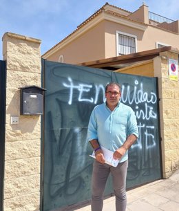 Andrés Parrado, candidato del PP a la Alcaldía de Coria del Río, en la puerta de su domicilio, donde han hecho pintadas con "amenazas".