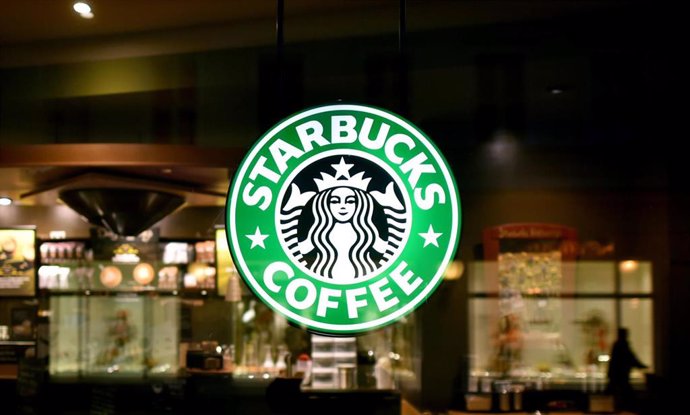 Archivo - FILED - 26 January 2015, Potsdam: The Starbucks logo illuminates a branch in Potsdam. Photo: Ralf Hirschberger/zb/dpa