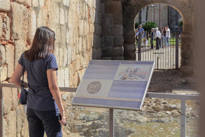 Una turista lee un cartel informativo en la Alcazaba de Mérida.
