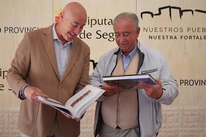 El diputado de deportes y el delegado de la federación de Fútbol en Segovia con el libro sobre el centenario.
