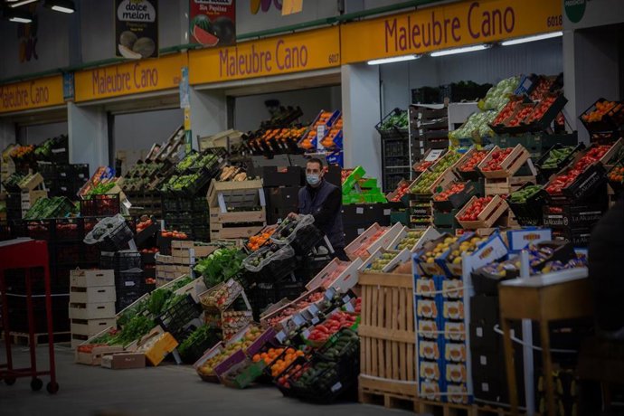 Archivo - Un trabajador junto a un puesto de frutas en Mercabarna, en Barcelona, Catalunya (España).