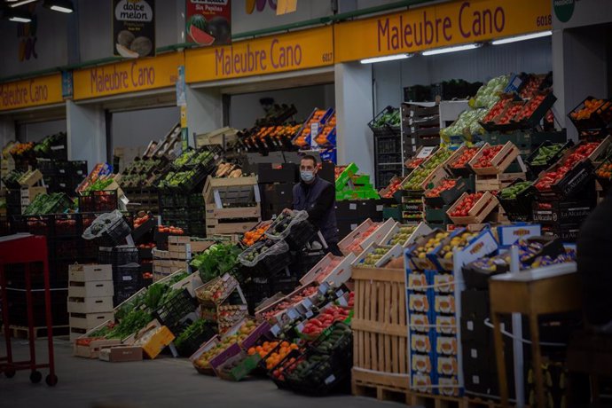 Archivo - Un treballador al costat d'una parada de fruites a Mercabarna