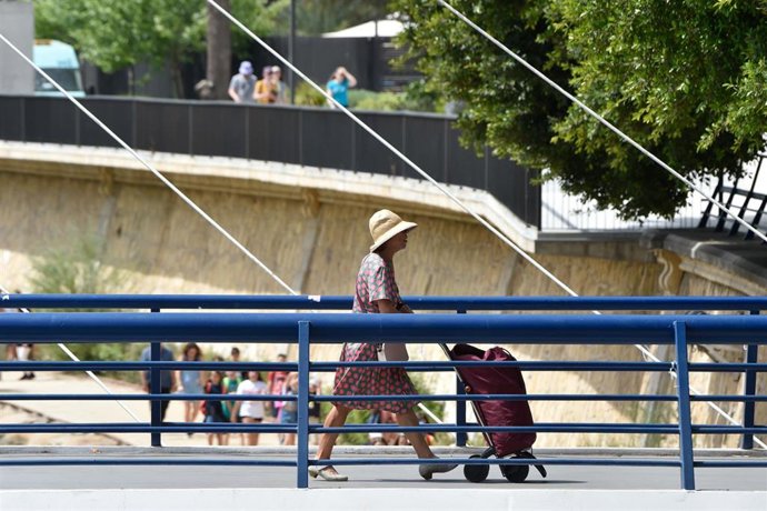 Una mujer pasean por la calle con un sombrero, a 27 de abril de 2023, en Murcia, Región de Murcia (España)
