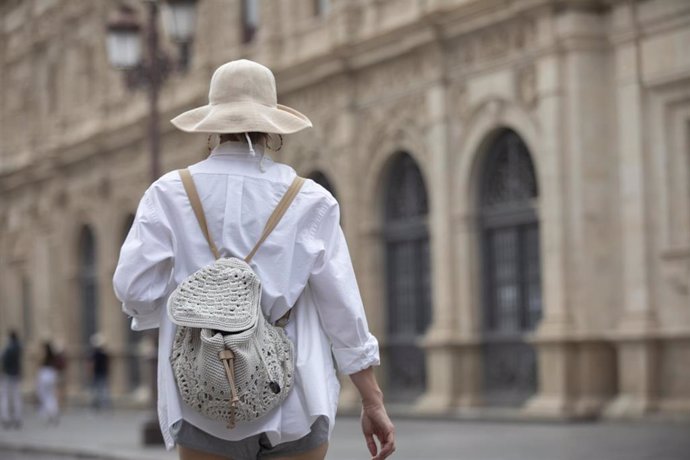 Turista con sombrero pasea por el centro de Sevilla.