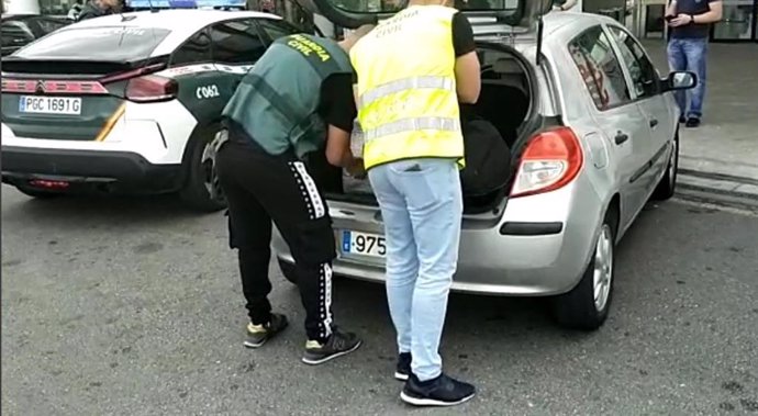 Guardias civiles investigando efectos presuntamente robados dentro de un coche de un sospechoso