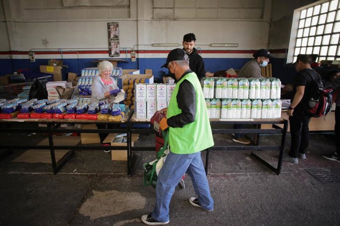 Voluntarios atienden a las personas que vienen a buscar comida en el almacén del Banco de Alimentos de Lugo.
