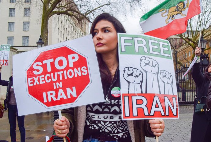 Archivo - January 14, 2023, London, United Kingdom: A protester holds 'Stop executions in Iran' and 'Free Iran' placards during the demonstration. Demonstrators gathered outside Downing Street in protest against executions in Iran and in support of free