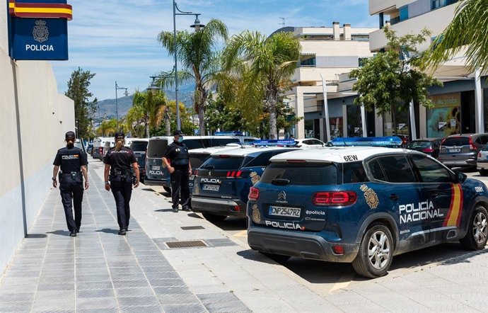 Agentes de la Policía Nacional junto a vehículos oficiales