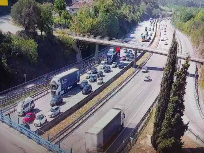 Imatge d'un vehicle bolcat a l'AP-7 a l'altura de Fogars de la Selva (Barcelona) que talla un carril de la via en sentit nord i provoca cues d'uns 8 quilmetres