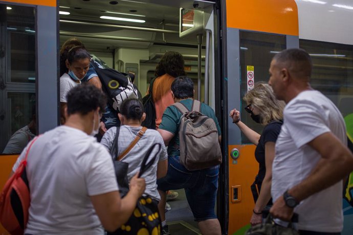 Archivo - Viatgers pugen a un tren en una de les andanes de l'estació de Sants a Barcelona