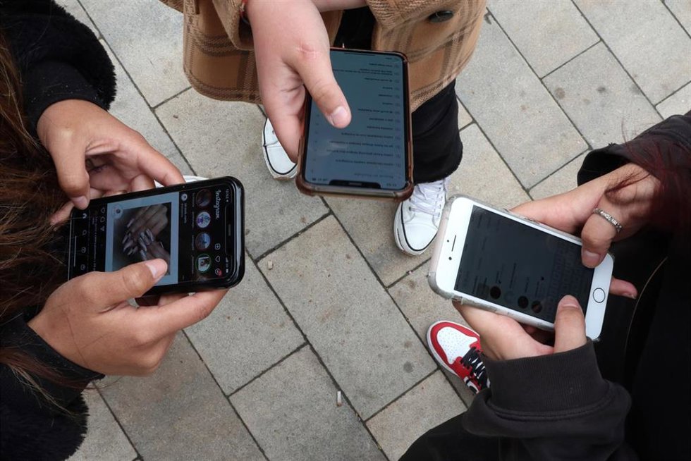 Archivo - Jóvenes utilizando sus teléfonos móviles
