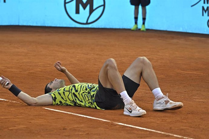 El tenista español Carlos Alcaraz yace en el suelo tras ganar el Mutua Madrid Open 2023