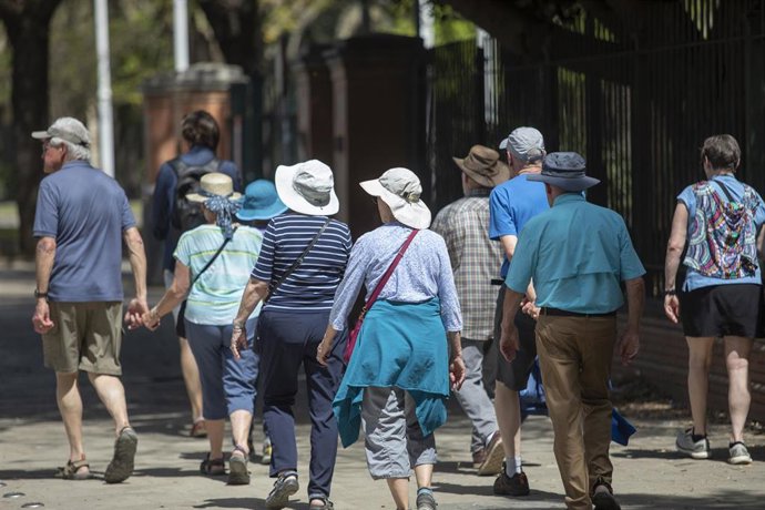 Un grupo de turistas pasea por la ciudad ataviados con sombreros para protegerse del sol y las altas temperaturas. 