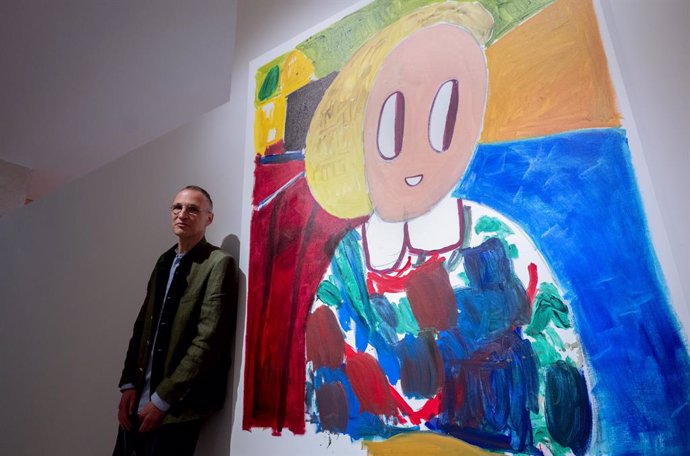 El artista André Butzer posa junto a una obra de su primera retrospectiva en una institución fuera de su país, en el Museo Nacional Thyssen-Bornemisza, a 8 de mayo de 2023, en Madrid (España). Coincidiendo con el 50 aniversario del artista, la muestra r