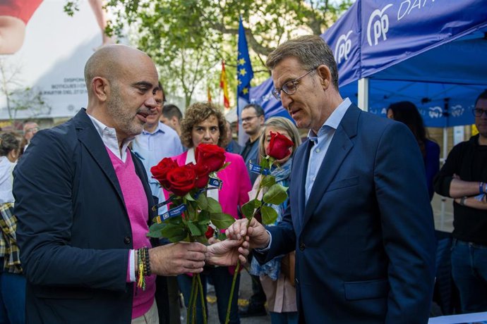 El presidente del Partido Popular, Alberto Núñez Feijóo (d), recibe una rosa del candidato a la alcaldía de Barcelona por el PP, Daniel Sirera (i), que asisten juntos a  la parada de Sant Jordi del partido en la Rambla de Catalunya, a 23 de abril de 202