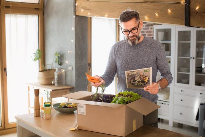 Un compradaor online recibe un pedido en su domicilio.