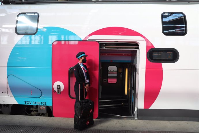 Archivo - Una empleada espera en la puerta de un tren durante la inauguración del primer trayecto de Ouigo, a 7 de mayo de 2021