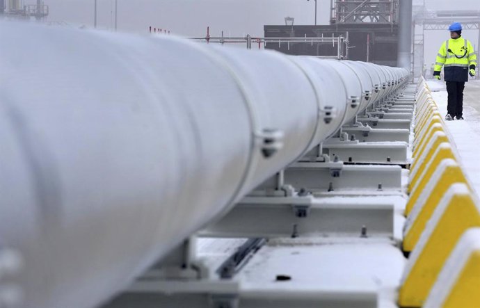 Archivo - 17 December 2022, Lower Saxony, Wilhelmshaven: A worker walks past a gas pipe connecting the special ship "Hoeegh Esperanza" to the mainland during the opening of the LNG terminal in Wilhelmshaven. Photo: Michael Sohn/POOL AP/dpa