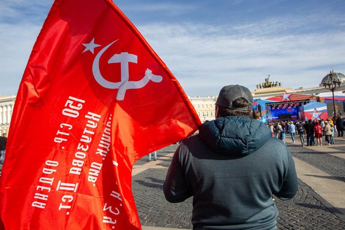 May 9, 2023, Saint Petersburg, Russia: A man watches a festive concert dedicated to Victory Day while holding a Soviet flag at the Palace Square. Russia celebrated the 78th anniversary of the complete and final victory in the Great Patriotic War over Na
