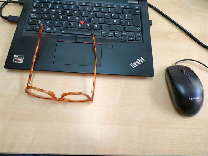 Archivo - Gafas y ordenador en la oficina. Imagen de archivo.