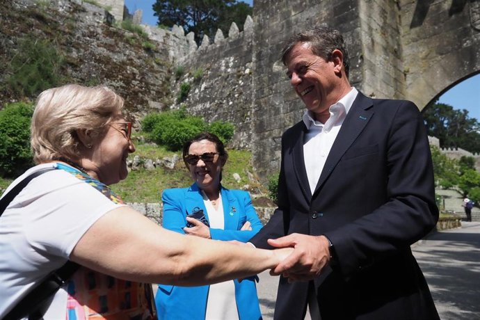 El delegado del Gobierno en Galicia, Xosé Ramón Gómez Besteiro, saluda a una mujer en Baiona, en presencia de la subdelegada en Pontevedra, Maica Larriba.