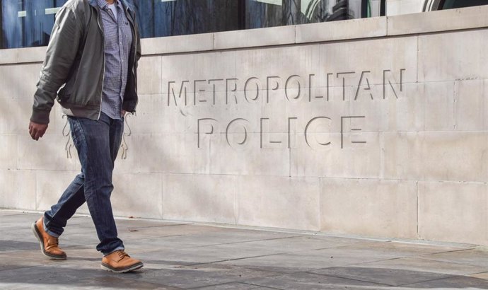 Archivo - Un hombre camina frente a la sede de la Policía Metropolitana de Londres