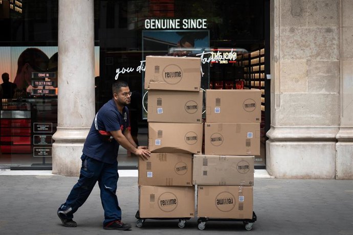 Un repartidor con una carretilla, a 10 de mayo de 2023, en Barcelona, Catalunya (España). 