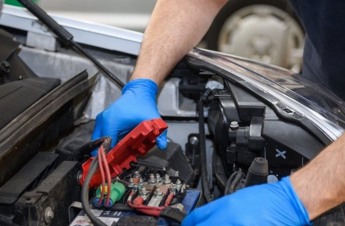 Archivo - Imagen de un operario manipulando una batería de un coche.